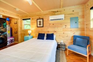 a bedroom with a bed and a blue chair at Cozy Hikers Hideaway Steps From Creeper Trail! in Damascus