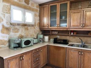 PouládesにあるΠέτρινη ιδιωτική βίλα με πισίναのキッチン(木製キャビネット、シンク、電子レンジ付)