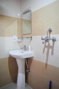 Subedi Apartment في بوخارا: حمام مع حوض ومرآة على الحائط
