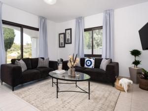 a living room with two couches and a table at Sunny Paradise Luxury Villa With Pool & Hot Tub in Paphos City