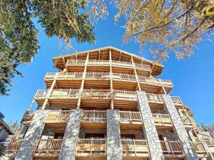 un edificio alto de madera con un cielo azul en el fondo en Appartement Montvalezan-La Rosière, 3 pièces, 9 personnes - FR-1-275-197 en La Rosière