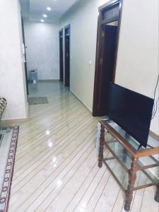 ein Wohnzimmer mit einem TV auf einem Holzboden in der Unterkunft Apartment pour les familles avec 2 chambres in Al Hoceïma