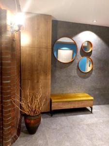 um quarto com um banco e espelhos na parede em Baykara Hotel em Konya