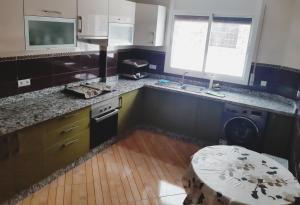 eine Küche mit einem Waschbecken und einem Tisch darin in der Unterkunft Apartment pour les familles avec 2 chambres in Al Hoceïma