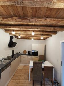 a kitchen with wooden ceilings and a table and chairs at Das Kirch24 - DAS Ferienhaus in Heidenburg in Heidenburg