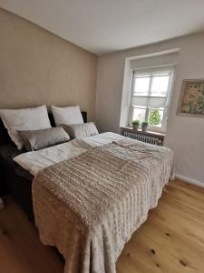 a large bed in a bedroom with a window at Das Kirch24 - DAS Ferienhaus in Heidenburg in Heidenburg