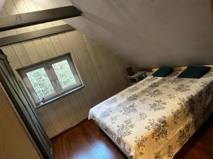 a bedroom with a bed and a window at Lille Bornholm in Banie Mazurskie