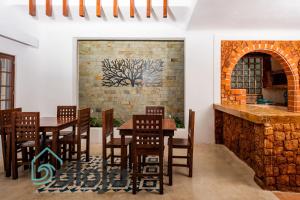 a restaurant with wooden tables and chairs and a brick wall at VIca Guest House con piscina en la entrada de la Zona Hotelera in Cancún