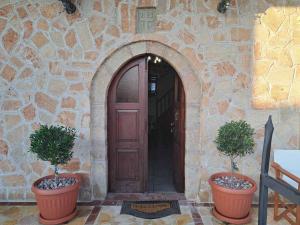 Matina's traditional house في شاراكي: اثنين من النباتات الفخارية تقف أمام الباب