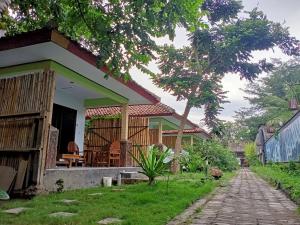 a house with a pathway in front of it at Creative Bungalow Beach Front in Gili Trawangan