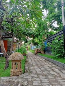 a stone walkway with a bird bath in a park at Creative Bungalow Beach Front in Gili Trawangan