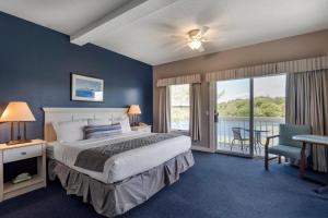 a bedroom with a bed and a balcony at Sebasco Harbor Resort & Golf Club in Sebasco Estates +100 photos