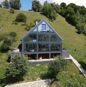 una casa en la cima de una colina con cristal en On Top Chalet, en Bran
