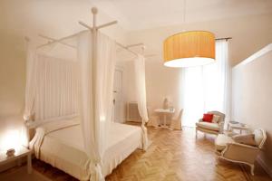 een slaapkamer met een wit hemelbed en een stoel bij Malìa bed and breakfast in Lecce