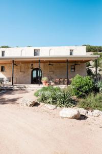 a building with a dirt road in front of it at Contigo Ranch Fredericksburg in Fredericksburg