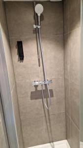 eine Dusche mit Duschkopf im Bad in der Unterkunft Happiness in Brügge