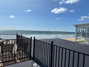 a balcony with two chairs and a view of the beach at Abellona Inn & Suites in Old Orchard Beach