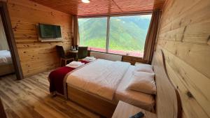 a bedroom with a bed and a large window at Kar Hotel Uzungöl in Uzungol