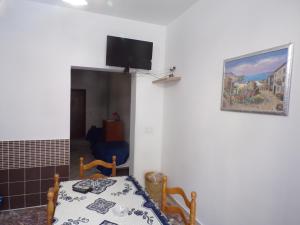 a room with a bed and a tv on the wall at LA CASA DEL LIMONE - Via Umberto 477 in Roccalumera