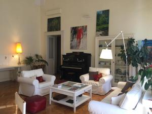 een woonkamer met witte meubels en een piano bij Malìa bed and breakfast in Lecce