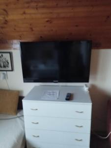 a flat screen tv on top of a white dresser at Nóra Vendégház in Abádszalók