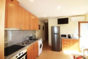 a kitchen with a stainless steel refrigerator and a sink at Casa dos Meoes in Geres