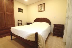 um quarto com uma cama de madeira e uma cómoda de madeira em Casa dos Meoes no Gerês