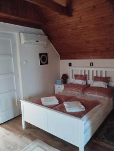 um quarto com uma grande cama branca num quarto em Nóra Vendégház em Abádszalók