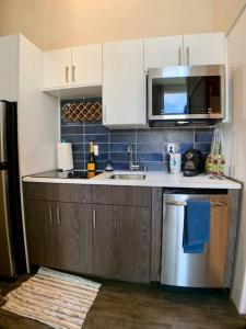 a kitchen with a sink and a refrigerator at Lofty Studio Prime Cap Hill Area Mins to Downtown in Seattle