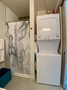 a washer and dryer in a bathroom with a shower curtain at Lofty Studio Prime Cap Hill Area Mins to Downtown in Seattle
