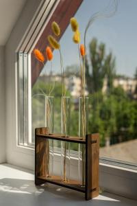 a vase with flowers in it sitting in a window at TREND HOUSE Apartments in Vinnytsya