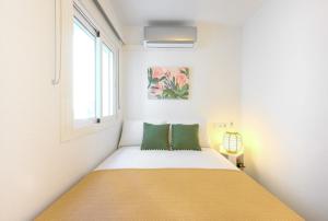 niewielka sypialnia z łóżkiem z 2 zielonymi poduszkami w obiekcie Belgica 2 - 2 room city & beach by 10ToSea w mieście Fuengirola