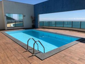 a large swimming pool in a building with a large window at Ocean Flat 707 - Praia da Costa in Vila Velha