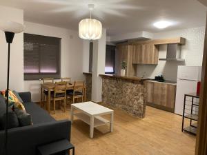 a living room and kitchen with a couch and a table at Apartamentos El Valle in Riópar