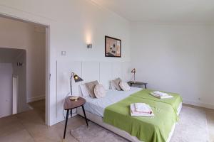 a bedroom with a bed with a green blanket at BmyGuest - Vilamoura Marina's View in Vilamoura