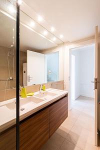 une salle de bain avec un lavabo et un grand miroir dans l'établissement BmyGuest - Vilamoura Marina's View, à Vilamoura
