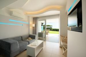 a living room with a couch and a tv at Mitsis Bali Paradise Hotel in Bali