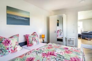 a bedroom with a bed with a floral bedspread at Casa Ka Sol in Bodman-Ludwigshafen