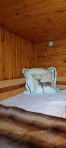 Bett in einem Zimmer mit Holzwänden in der Unterkunft L'Ard'Heure D'Avance in Somme-Leuze