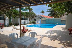 a patio with a table and chairs and a pool at Magico Apartamento Frente al Mar 2 Habitaciones B22B in Coveñitas +14 photos