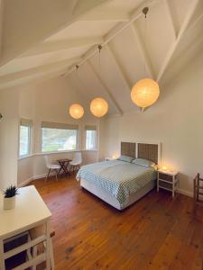 a bedroom with a bed and a table and some lights at Villa Amanzi in Hout Bay