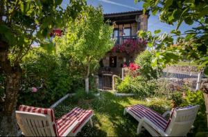 un jardín con 2 sillas y una casa en Casa LaCarusa 28 