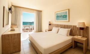 Cette chambre d'hôtel comprend un lit et un balcon. dans l'établissement Mitsis Bali Paradise Hotel, à Balíon