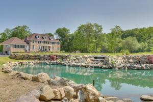 una casa con una pared de piedra y una piscina de agua en Carpathia West Estate - 7-Bedroom Villa!, en Hewitt