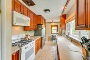 una cucina con armadi in legno e un piano cottura bianco con forno di Charming Canandaigua Lake House with Deck and Views! a Rushville