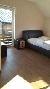 a bedroom with a bed and a dresser and a window at Dom Apart Magda Rewal in Rewal