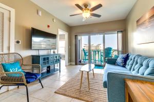 un salon avec un canapé bleu et une télévision dans l'établissement Bayfront Pensacola Beach Condo with Pool and Elevator, à Pensacola Beach