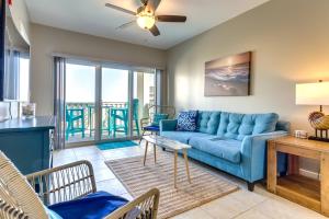 - un salon avec un canapé bleu et une table dans l'établissement Bayfront Pensacola Beach Condo with Pool and Elevator, à Pensacola Beach