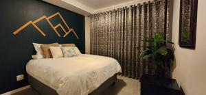 ein Schlafzimmer mit einem großen Bett und einer Wand mit k-Pfeilen in der Unterkunft Accommodation Front - Charming 2 Sleeper in Point Waterfront in Durban