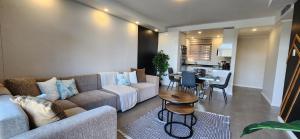 ein Wohnzimmer mit Sofa und Tisch in der Unterkunft Accommodation Front - Charming 2 Sleeper in Point Waterfront in Durban + 14 Fotos